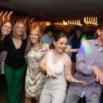 Un fotógrafo profesional capturando momentos inolvidables en un evento especial, con un juego de luces y sombras que refleja la emoción del momento