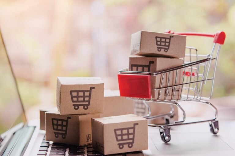 Cajas de cartón con carrito de compras sobre un teclado de laptop, concepto de tienda online y compras por internet