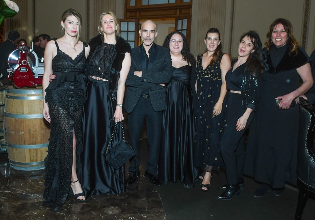 Grupo de invitadas con vestidos de gala negros posa junto a un hombre en el Renato Papiccio Runway, Sofitel Montevideo