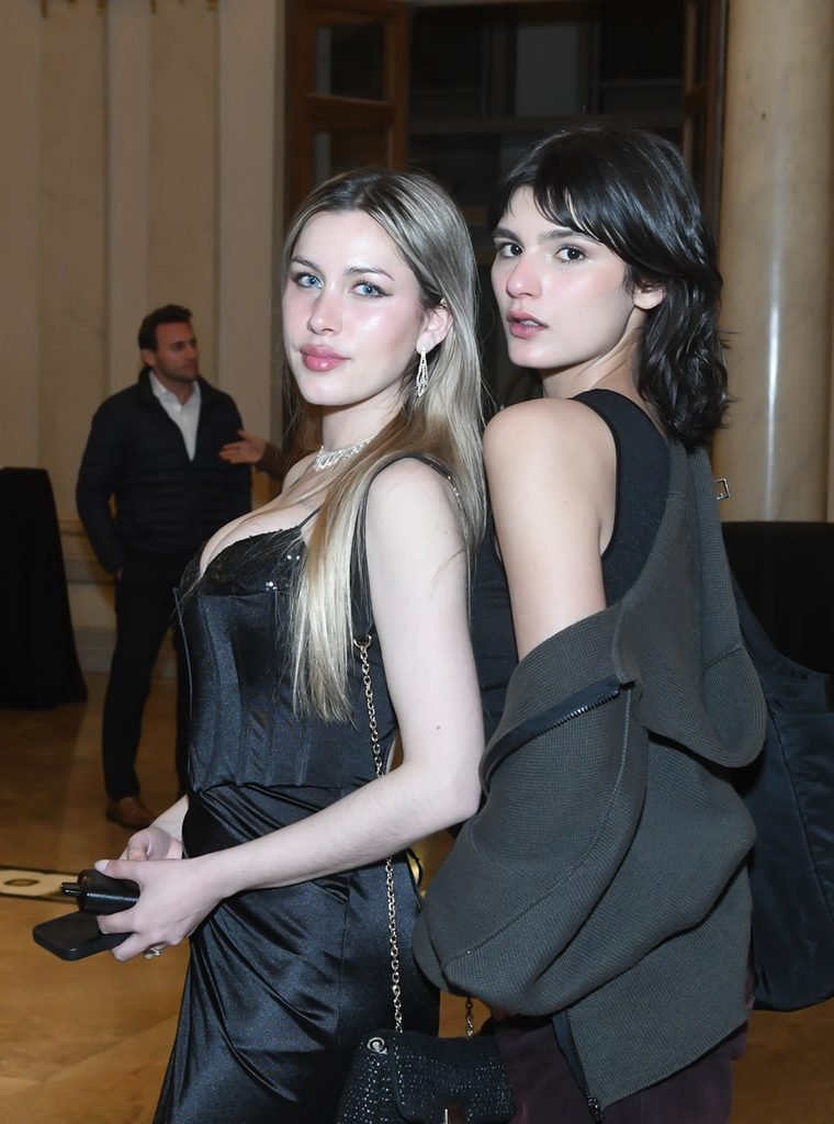 Dos jóvenes invitadas de negro posan juntas en el salón del Sofitel Montevideo