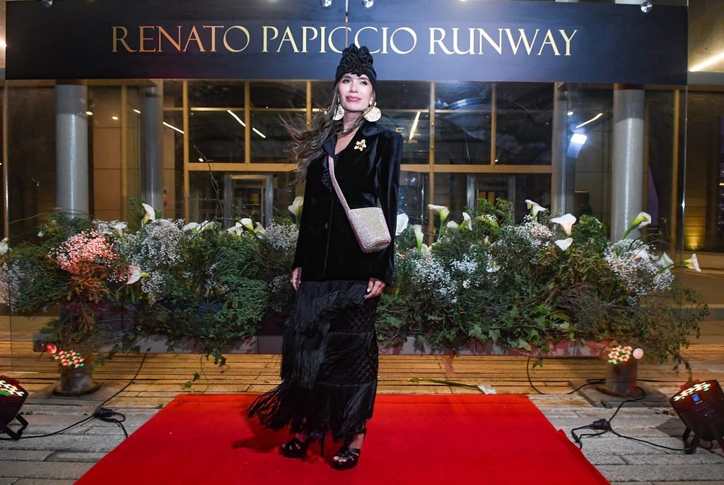 Invitada de chaqueta negra y falda larga posa en la alfombra roja del Renato Papiccio Runway