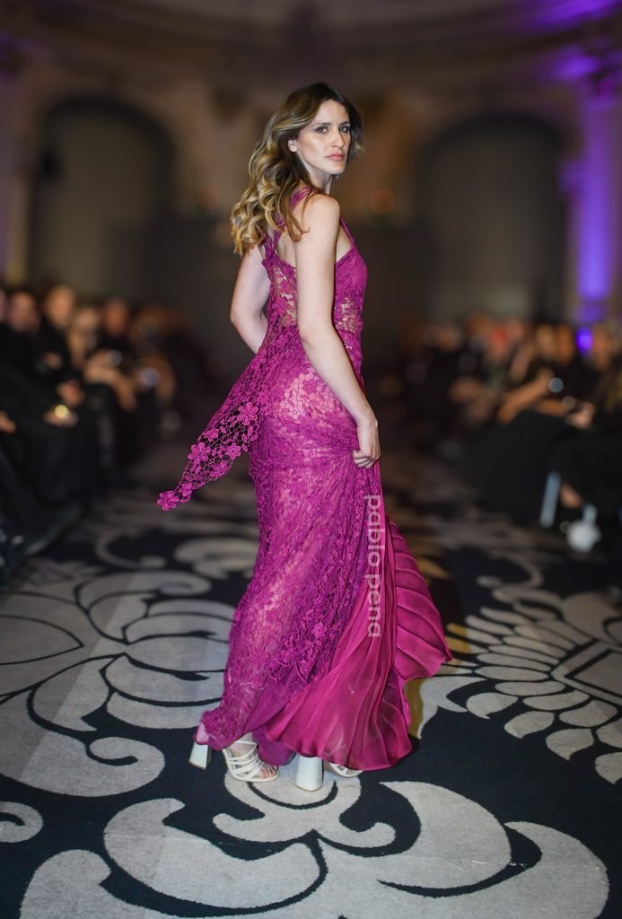 Modelo desfila de espaldas con vestido fucsia de encaje en la pasarela en el Renato Papiccio Runway, Sofitel Montevideo