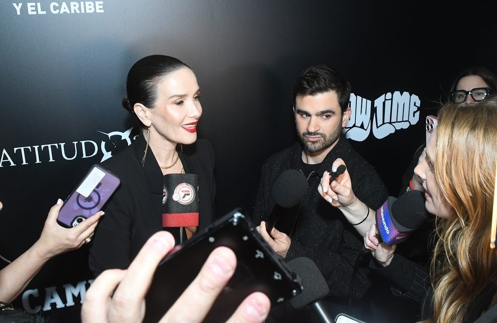 Invitada responde a la prensa frente a micrófonos y celulares en el Renato Papiccio Runway, Sofitel Montevideo