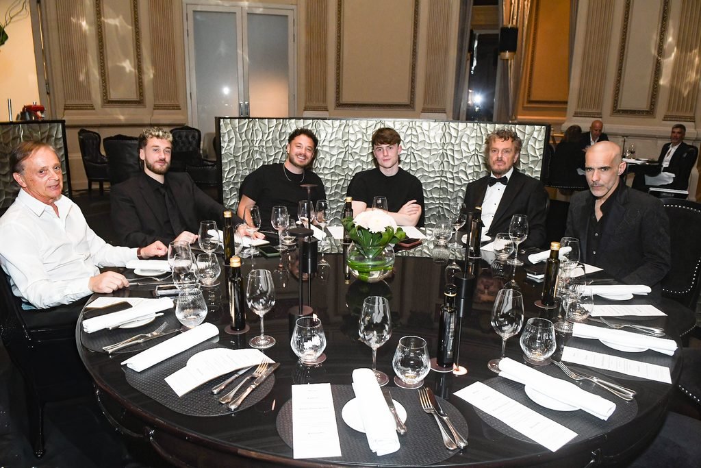 Invitados vestidos de negro comparten una mesa durante la cena en el Renato Papiccio Runway, Sofitel Montevideo