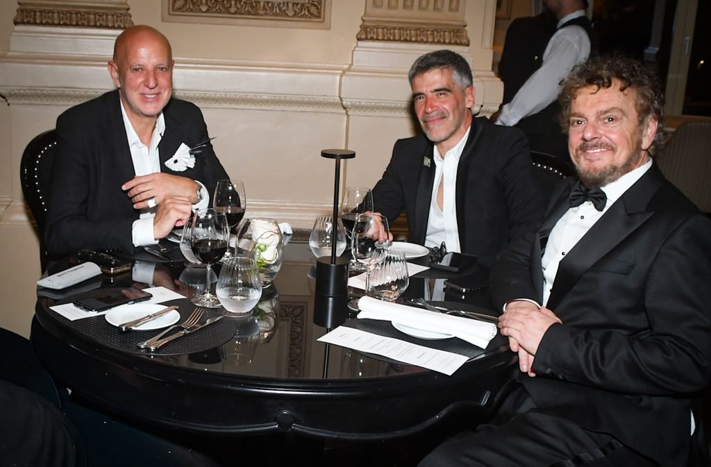 Tres hombres de traje sentados a la mesa durante la cena en el Renato Papiccio Runway, Sofitel Montevideo