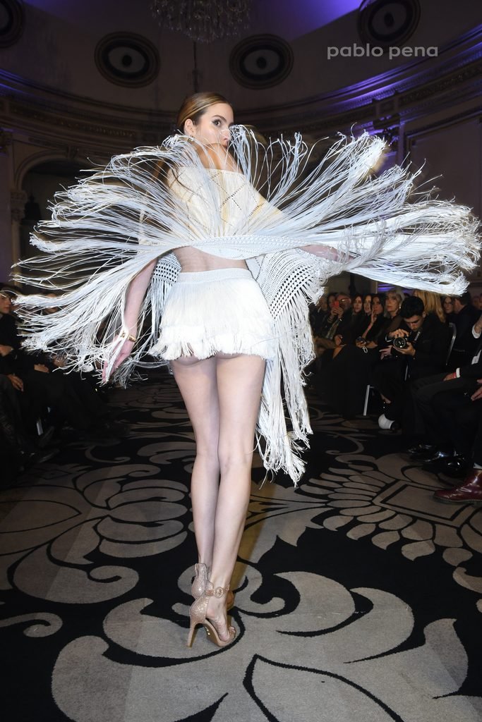 Modelo luce un diseño blanco con flecos que giran en la pasarela en el Renato Papiccio Runway, Sofitel Montevideo