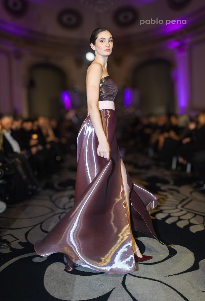 Modelo desfila con top strapless y falda larga satinada en tonos ciruela en el Renato Papiccio Runway, Sofitel Montevideo