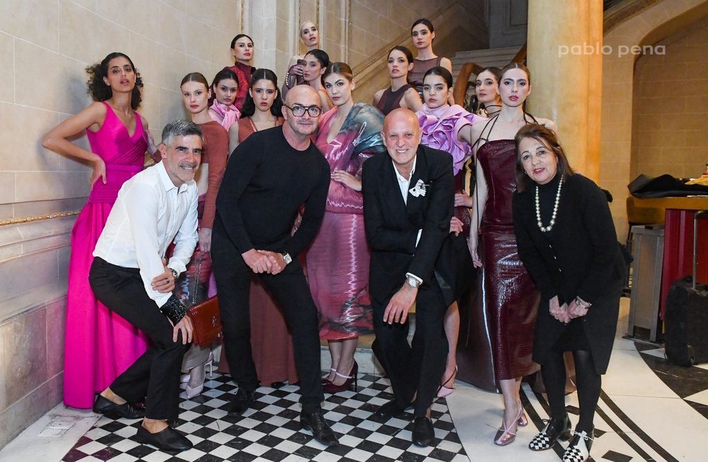 Diseñadores posan junto a modelos con vestidos fucsia y metalizados tras el desfile en el Renato Papiccio Runway, Sofitel Montevideo