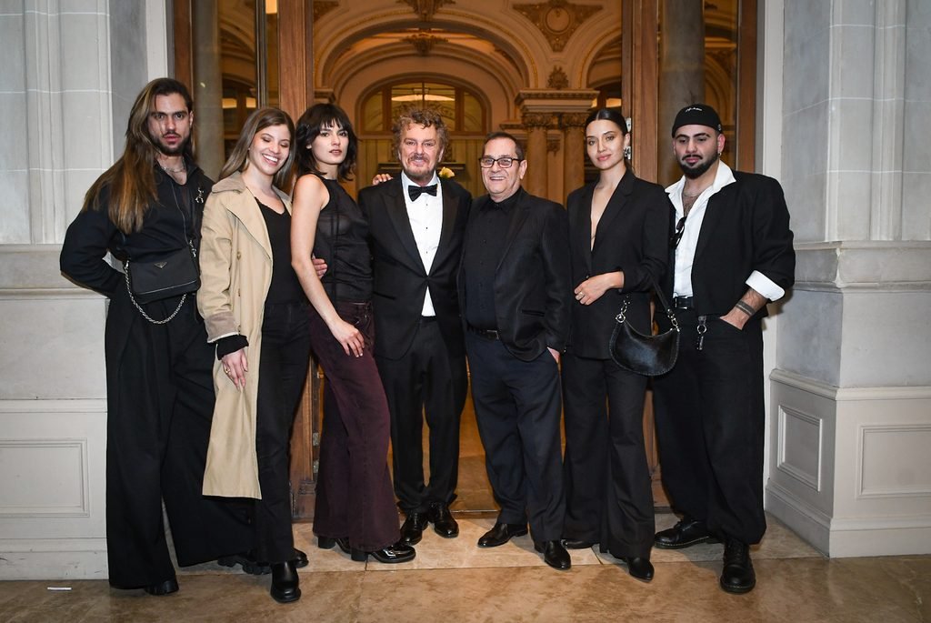 Grupo de siete invitados vestidos de negro posa en los salones del Sofitel Montevideo